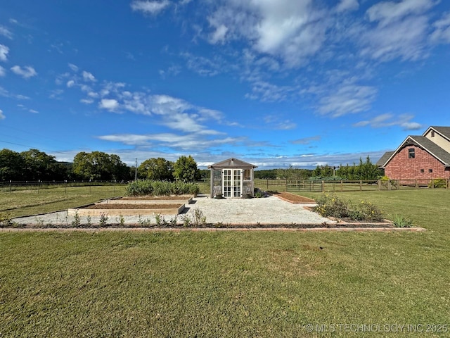 view of yard with an outbuilding, a rural view, and fence