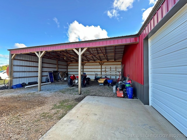 view of vehicle parking featuring a detached carport and a pole building