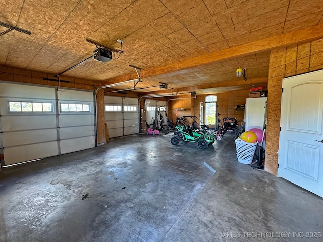 garage with a garage door opener and freestanding refrigerator