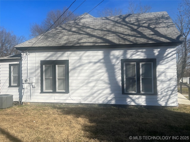 view of property exterior with a yard and central AC