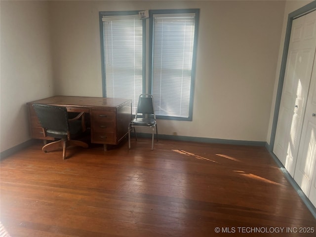 unfurnished office with baseboards and wood-type flooring