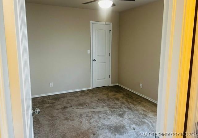 carpeted empty room with baseboards and a ceiling fan