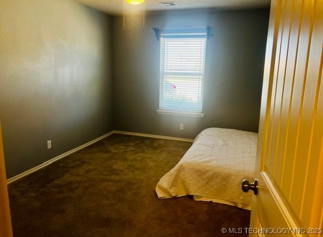 bedroom featuring baseboards and carpet