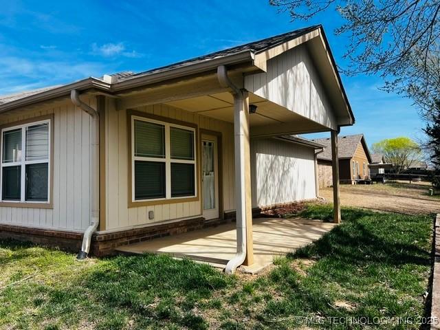 rear view of property featuring a patio area and a yard