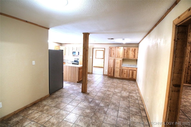 136 Pine St, Mead, OK 73449 - kitchen with crown molding, white microwave, freestanding refrigerator, and electric range oven