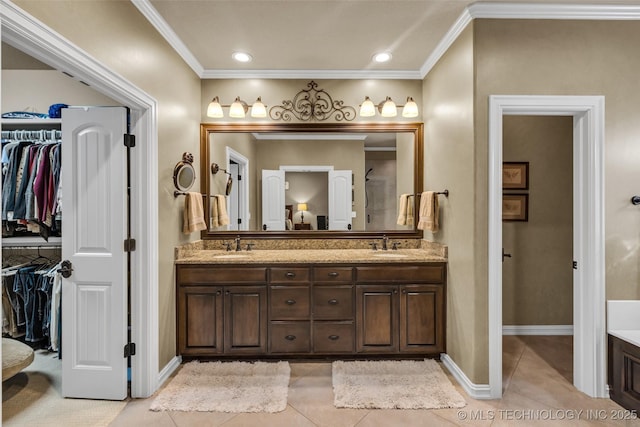 bathroom featuring double vanity, crown molding, a spacious closet, and tile patterned flooring