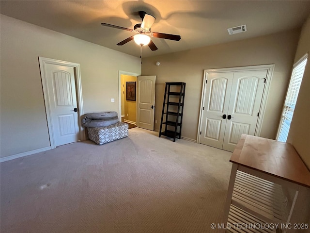 bedroom featuring a ceiling fan, a closet, baseboards, visible vents, and light colored carpet