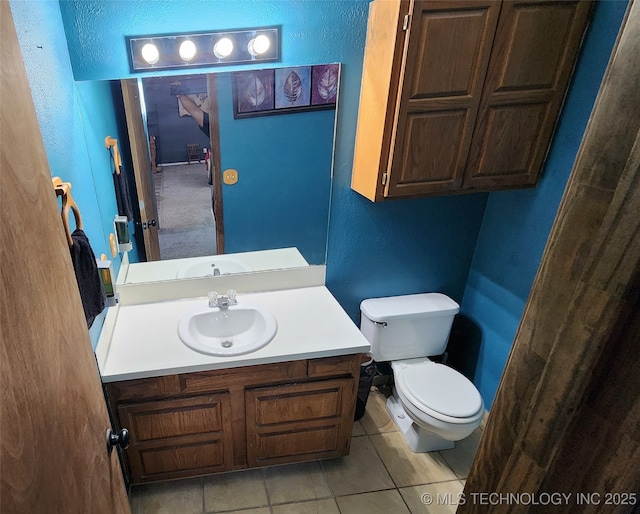 305 E 48th Pl, Sand Springs, OK 74063 - bathroom featuring a textured wall, tile patterned floors, vanity, and toilet