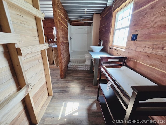 020 Haworth, Durant, OK 74701 - bathroom featuring toilet, a sink, a shower stall, wood finished floors, and wood walls