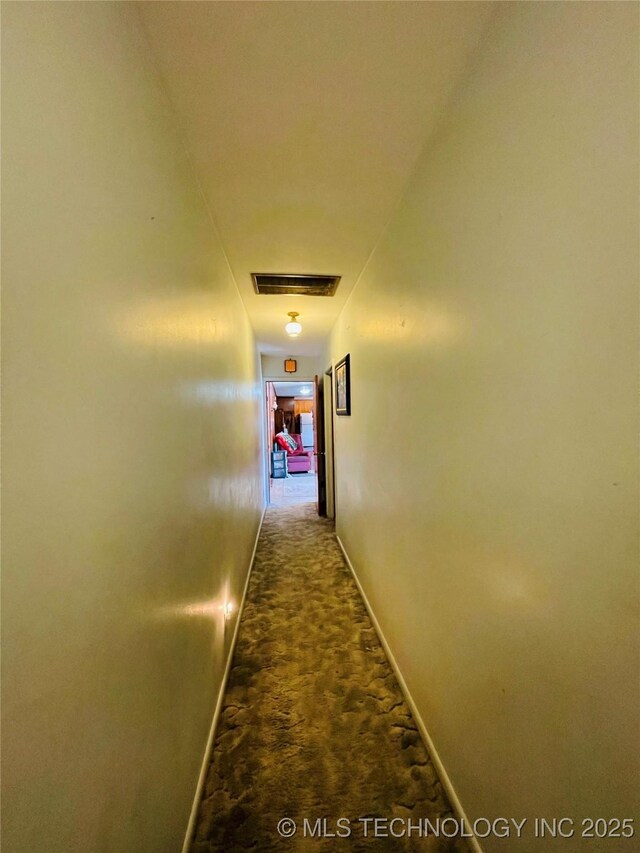 306 N Cherokee St, Beggs, OK 74421 - hallway featuring visible vents, baseboards, and dark colored carpet