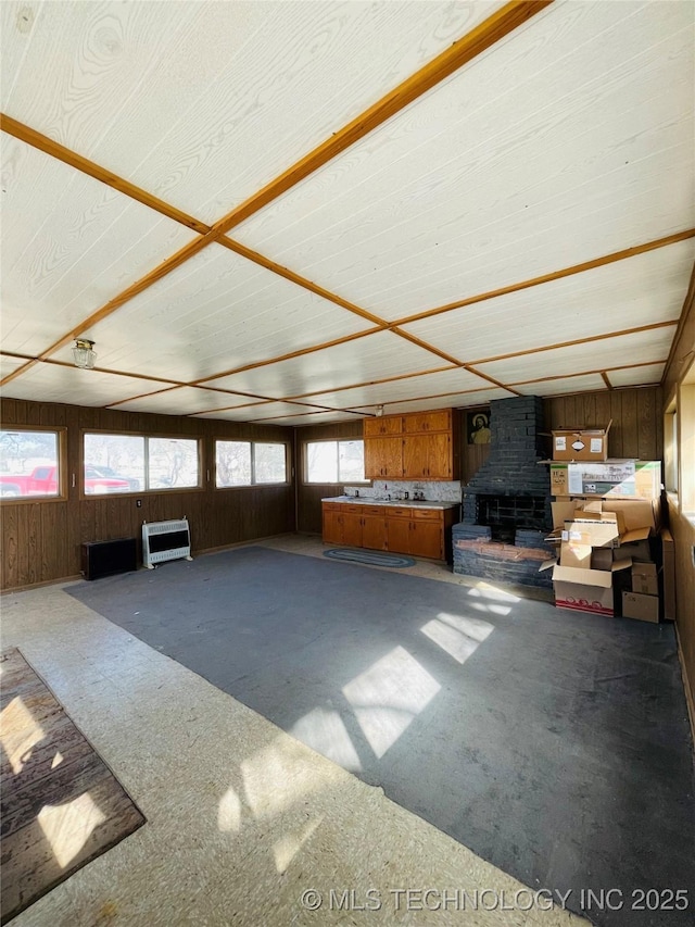 306 N Cherokee St, Beggs, OK 74421 - unfurnished living room featuring heating unit and wooden walls