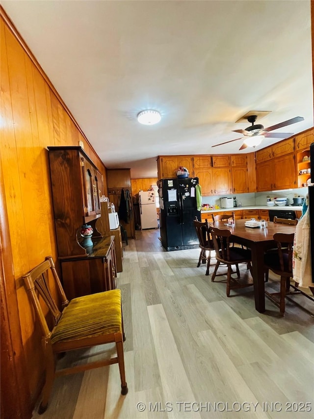 306 N Cherokee St, Beggs, OK 74421 - dining area featuring wood walls, light wood-type flooring, and a ceiling fan
