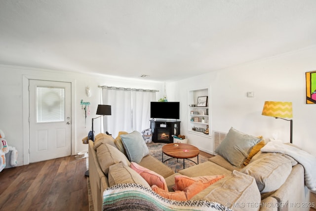 302 W 4th St, Skiatook, OK 74070 - living room featuring built in features, visible vents, a glass covered fireplace, and wood finished floors