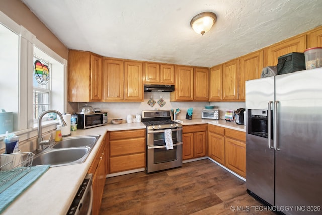 302 W 4th St, Skiatook, OK 74070 - kitchen with dark wood-style flooring, a sink, stainless steel appliances, light countertops, and under cabinet range hood