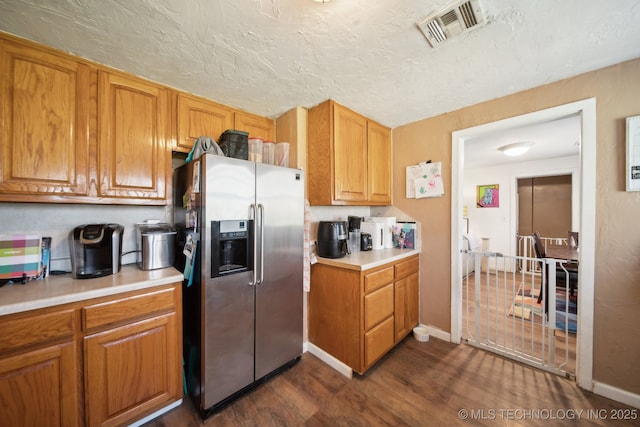 302 W 4th St, Skiatook, OK 74070 - kitchen with visible vents, light countertops, stainless steel refrigerator with ice dispenser, dark wood-style floors, and a textured ceiling