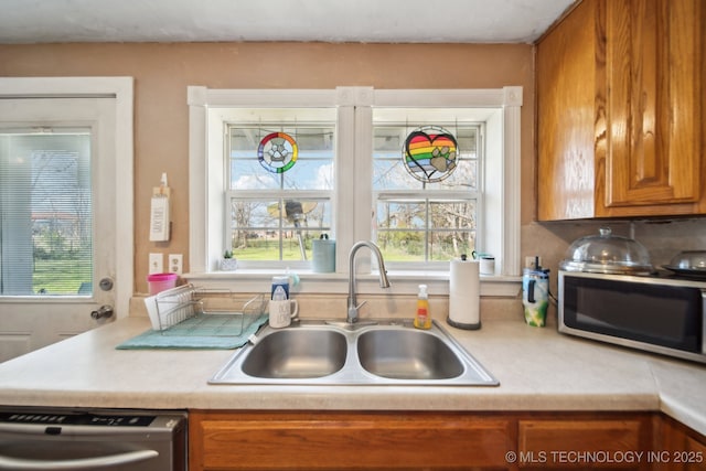 302 W 4th St, Skiatook, OK 74070 - kitchen featuring light countertops, stainless steel appliances, a wealth of natural light, and a sink