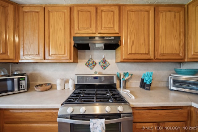 302 W 4th St, Skiatook, OK 74070 - kitchen featuring light countertops, brown cabinetry, under cabinet range hood, and stainless steel appliances