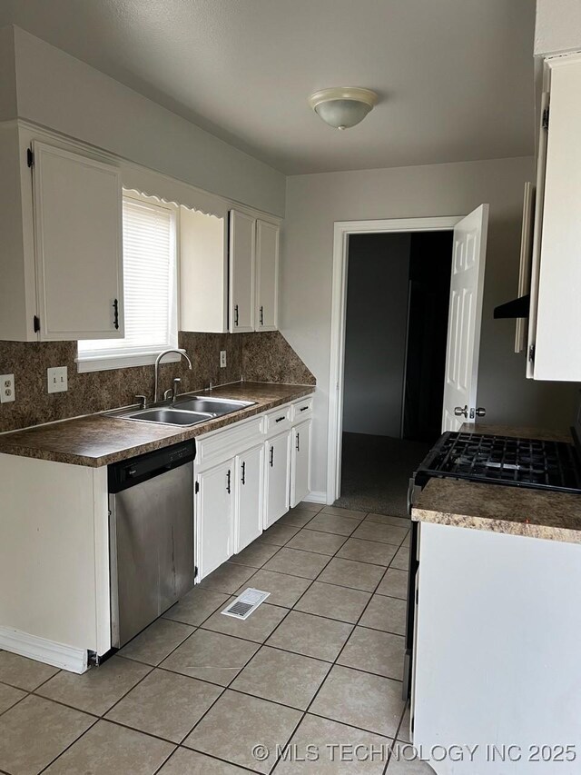 12802 E 31st Ct, Tulsa, OK 74146 - kitchen featuring white cabinetry, light tile patterned floors, appliances with stainless steel finishes, and a sink