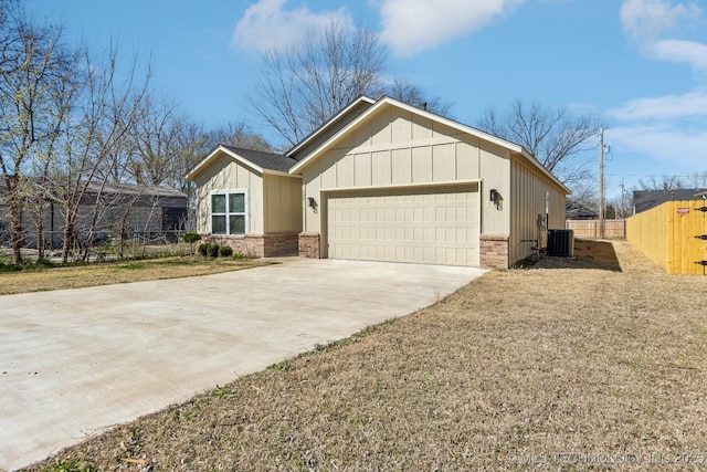 view of front of home featuring fence, board and batten siding, concrete driveway, a garage, and central AC unit