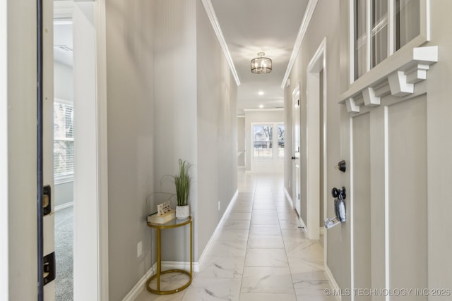 hall featuring crown molding, baseboards, and marble finish floor