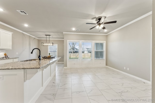 kitchen featuring a sink, visible vents, marble finish floor, and crown molding