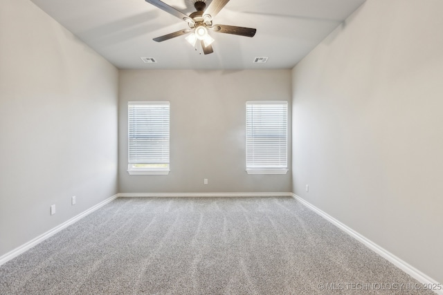 spare room with visible vents, carpet flooring, baseboards, and a ceiling fan