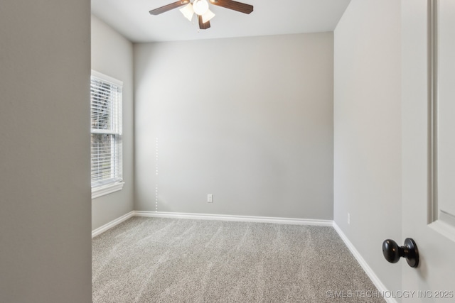 carpeted empty room with a ceiling fan and baseboards