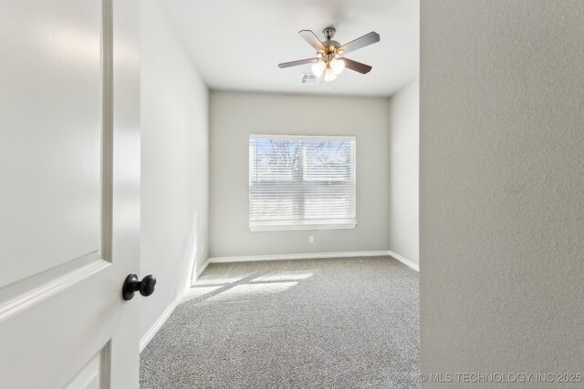 unfurnished room with visible vents, ceiling fan, baseboards, and carpet