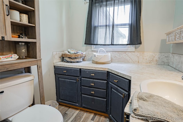 bathroom with vanity, toilet, and wood finished floors