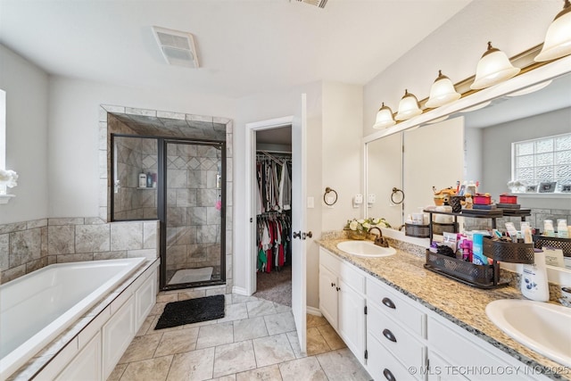 7610 N 127th E Ave, Owasso, OK 74055 - full bathroom featuring a stall shower, a garden tub, double vanity, and a walk in closet
