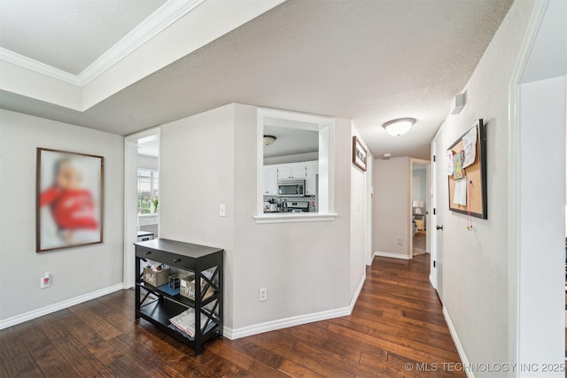 7610 N 127th E Ave, Owasso, OK 74055 - hallway with dark wood-style floors, ornamental molding, and baseboards