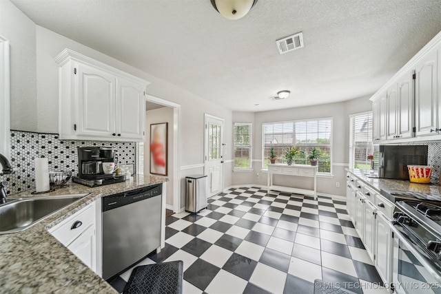 7610 N 127th E Ave, Owasso, OK 74055 - kitchen featuring dishwashing machine, a sink, stainless steel gas range, white cabinetry, and tasteful backsplash