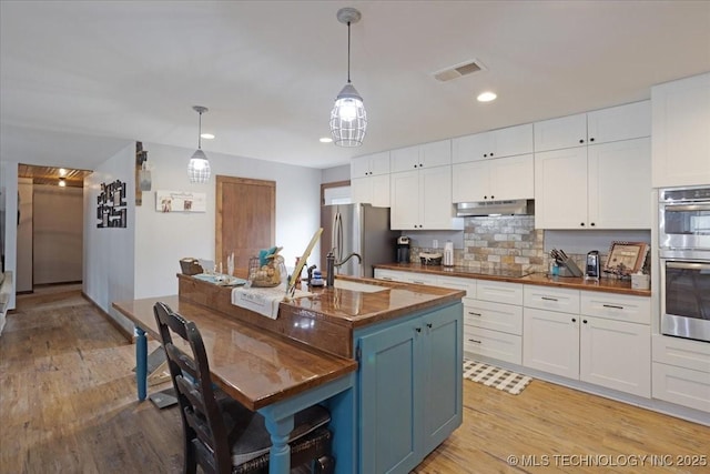 420722 E 1920th Rd, Antlers, OK 74523 - kitchen with under cabinet range hood, visible vents, appliances with stainless steel finishes, and white cabinetry