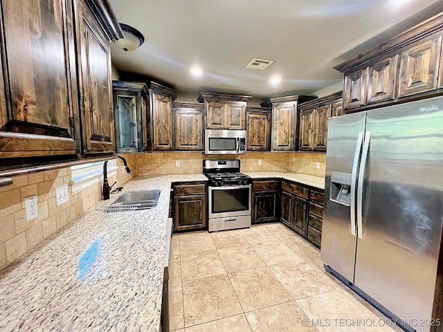 4169 Highland Dr, Tahlequah, OK 74464 - kitchen featuring appliances with stainless steel finishes, a sink, dark brown cabinets, decorative backsplash, and recessed lighting