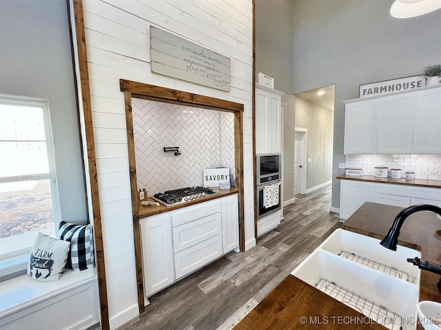 11457 N 510th Rd, Tahlequah, OK 74464 - kitchen featuring decorative backsplash, appliances with stainless steel finishes, a sink, a high ceiling, and dark wood-type flooring