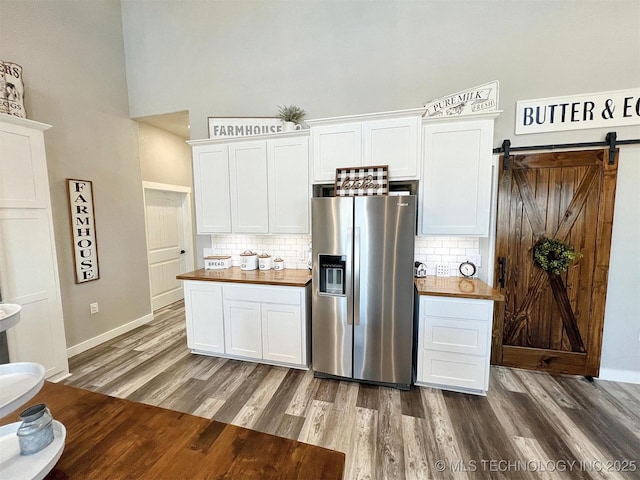 11457 N 510th Rd, Tahlequah, OK 74464 - kitchen with stainless steel refrigerator with ice dispenser, wood finished floors, a high ceiling, tasteful backsplash, and white cabinets