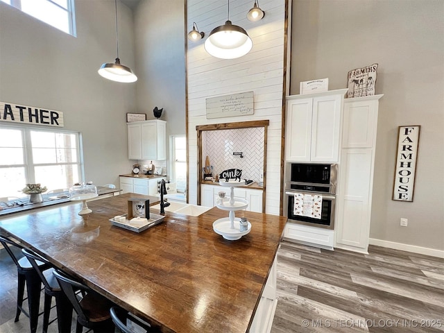 11457 N 510th Rd, Tahlequah, OK 74464 - dining room with a towering ceiling, wood finished floors, and baseboards