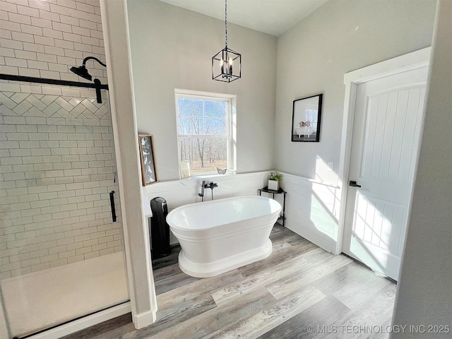 11457 N 510th Rd, Tahlequah, OK 74464 - full bath featuring a shower stall, wood finished floors, a freestanding tub, a wainscoted wall, and a chandelier