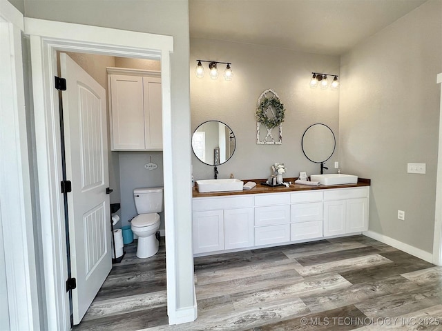11457 N 510th Rd, Tahlequah, OK 74464 - bathroom featuring wood finished floors, toilet, double vanity, and baseboards