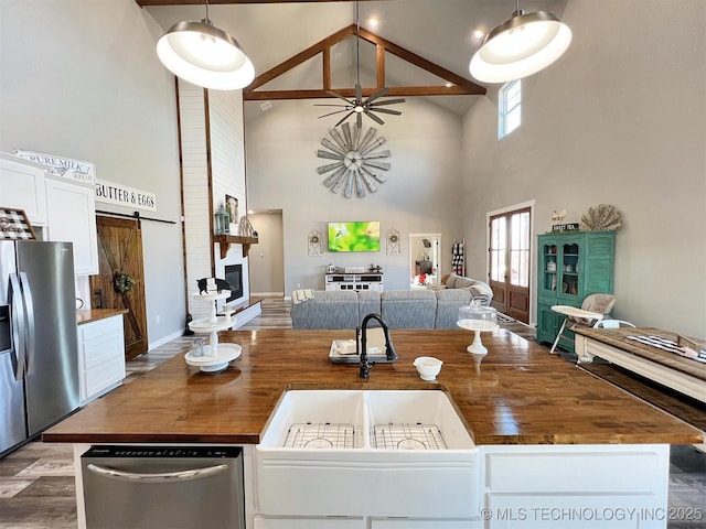 11457 N 510th Rd, Tahlequah, OK 74464 - kitchen featuring stainless steel refrigerator with ice dispenser, open floor plan, high vaulted ceiling, wooden counters, and wood finished floors