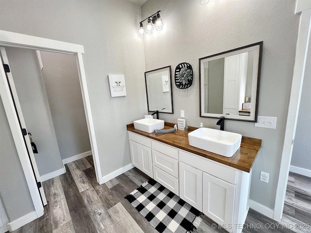 11457 N 510th Rd, Tahlequah, OK 74464 - bathroom featuring wood finished floors, double vanity, baseboards, and a textured wall