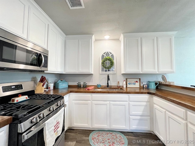 11457 N 510th Rd, Tahlequah, OK 74464 - kitchen featuring appliances with stainless steel finishes, a sink, white cabinets, dark wood-style flooring, and butcher block counters