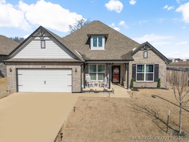 view of front of house featuring roof with shingles, concrete driveway, covered porch, brick siding, and an attached garage