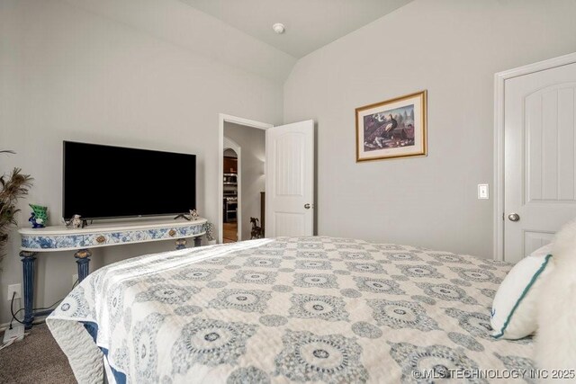 bedroom with arched walkways, lofted ceiling, and carpet