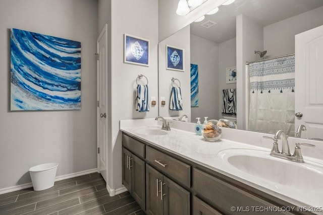 full bathroom with visible vents, baseboards, a sink, and wood tiled floor