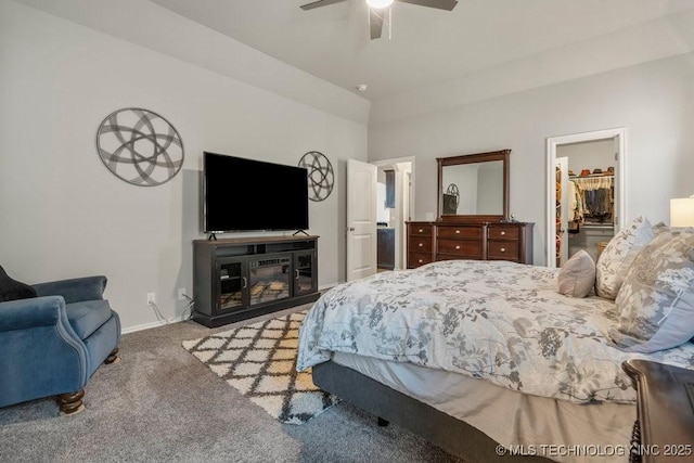 carpeted bedroom featuring ceiling fan, baseboards, a closet, and a walk in closet