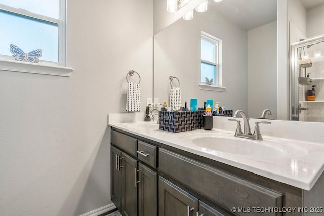 bathroom with a shower stall, a sink, and double vanity