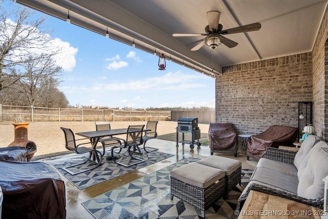 view of patio with outdoor dining space, area for grilling, a fenced backyard, and ceiling fan