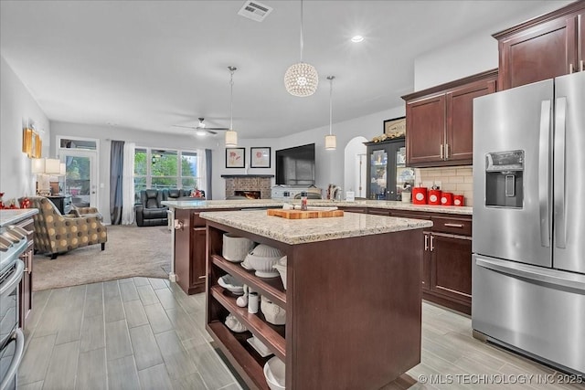 kitchen with stainless steel appliances, a peninsula, open floor plan, visible vents, and ceiling fan