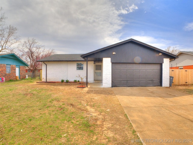 view of front facade with brick siding, concrete driveway, a garage, and fence